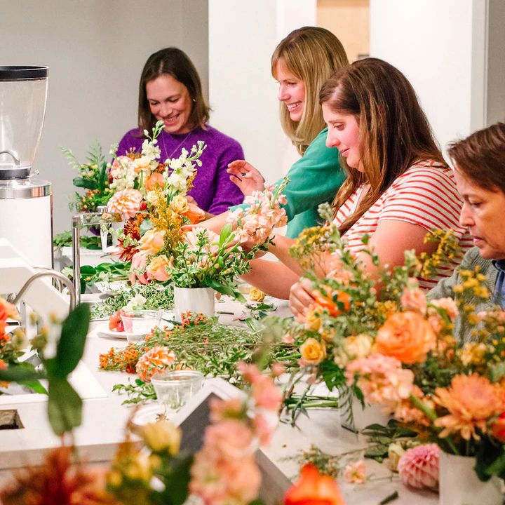 A candlelit Mediterranean table with wine, olive branches, citrus, and florals
